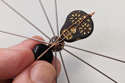 Wire ends that extend past the simple loop are folded to the back of the "spider" and aligned with its body.